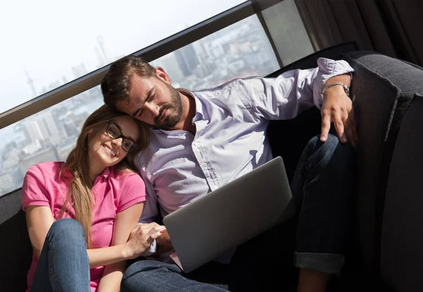 Pareja relajándose en casa usando computadoras portátiles — Foto de Stock