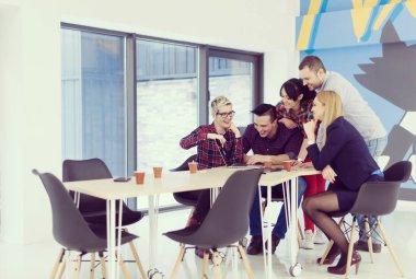 Girişim ekibi, modern parlak ofis içi beyin fırtınası, dizüstü bilgisayar ve tablet bilgisayar üzerine toplantı üzerine çalışıyor