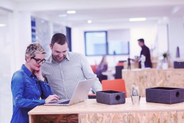 Girişim ekibi, modern parlak ofis içi beyin fırtınası, dizüstü bilgisayar ve tablet bilgisayar üzerine toplantı üzerine çalışıyor