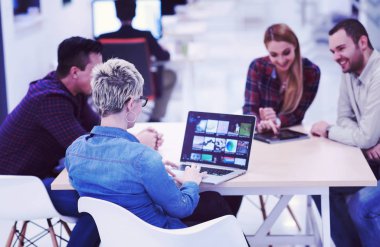 Girişim ekibi, modern parlak ofis içi beyin fırtınası, dizüstü bilgisayar ve tablet bilgisayar üzerine toplantı üzerine çalışıyor