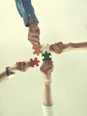Group of business people assembling jigsaw puzzle clipart
