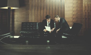 İş adamları el sıkışıyor, anlaşma yapıyor ve sözleşme imzalıyor.