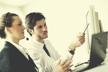Kulaklıklı iş adamları grubu müşterilere yardım masasında destek veriyor, yönetici eğitim ve eğitim talimatları veriyor
