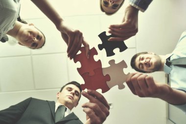 Bir grup iş adamı yapboz yapıyor ve takım desteği ve konsepti temsil ediyor.