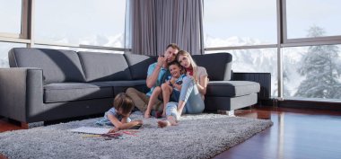 Mutlu Genç Aile, tablet ve çizim setiyle evde birlikte oynuyor.