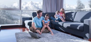 Mutlu bir aile. Baba, anne ve çocuklar video oyunu oynuyorlar. Baba ve oğul yerde oyun oynuyorlar.