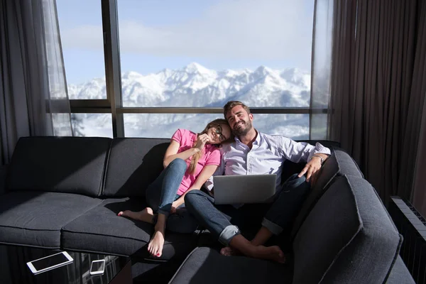 Casal relaxante em casa usando computadores portáteis — Fotografia de Stock