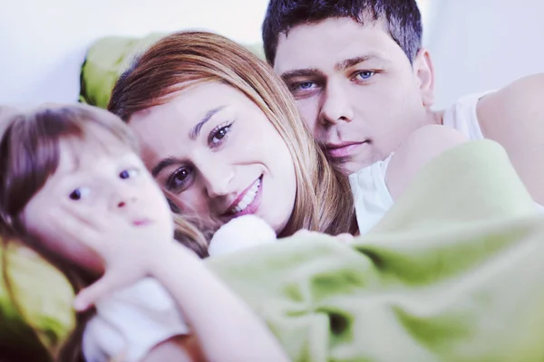 Ontspannen in bed en gelukkige familie — Stockfoto