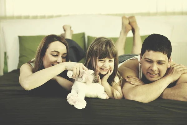 Familia feliz relajarse en la cama — Foto de Stock