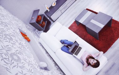 Moder Home 'da kablosuz bilgisayarda çalışırken dinlenen güzel genç bir kadın. 