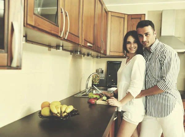 Feliz jovem casal se divertir na cozinha moderna — Fotografia de Stock