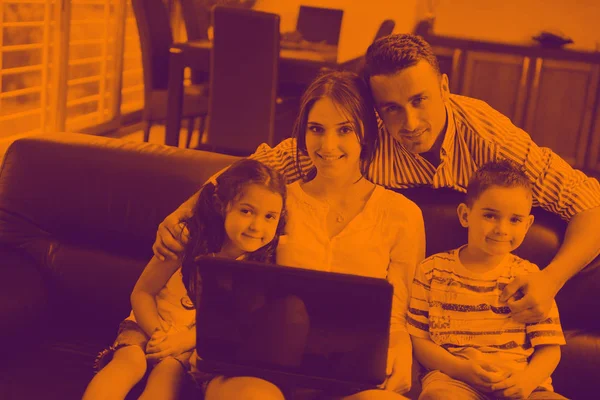 Šťastný, mladá rodina pobavit a pracují na notebooku doma — Stock fotografie