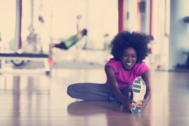 mutlu genç Afro-Amerikan kadın bir spor salonu ve germe egzersiz genç mab arka planda dumbbells ile egzersiz öncesine Isınma