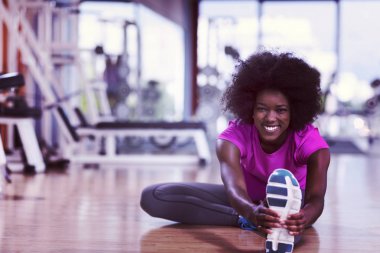 mutlu genç Afro-Amerikan kadın bir spor salonu ve germe egzersiz genç mab arka planda dumbbells ile egzersiz öncesine Isınma