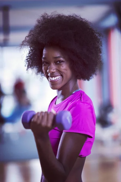 Woman working out in a crossfit gym with dumbbells — Stock Photo, Image