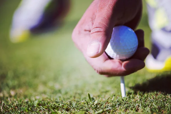 高尔夫选手将球放在球座上 — 图库照片