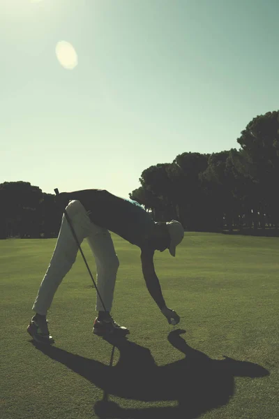 Golf-lejátszó helyezve a labdát a póló — Stock Fotó