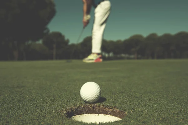 Golf-spelare slå skott, bollen på kanten av hål — Stockfoto