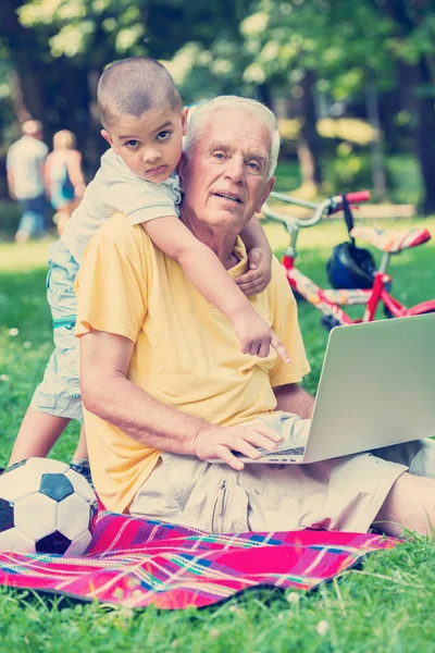 Grandfather and child using laptop — Stock Photo, Image