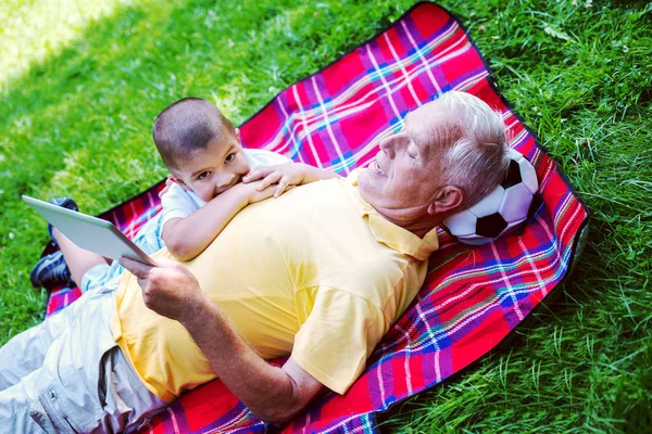 Grand-père et enfant dans le parc en utilisant la tablette — Photo