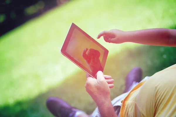 Grootvader en kind in het park met tablet — Stockfoto