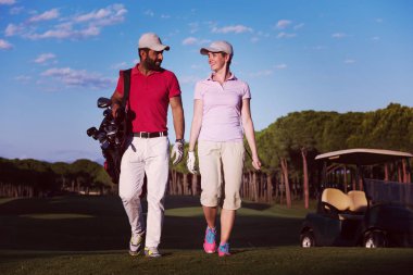 Genç çift golf sahasındaki bir sonraki deliğe yürüyor.