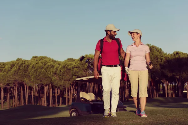 若いカップルがゴルフ場の隣の穴まで歩いて — ストック写真