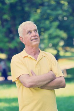 Yeşil arka plan parkında sağlıklı ve formda bir yaşlı portresi.