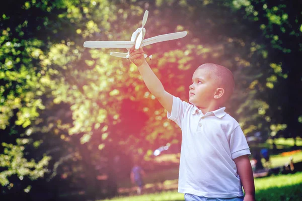 幸せな少年再生し 公園で飛行機を投げる — ストック写真