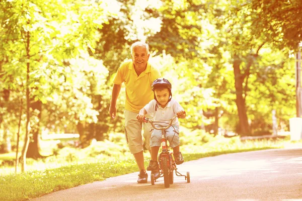 快乐的祖父和孩子有乐趣在公园在美丽的阳光明媚的一天 — 图库照片