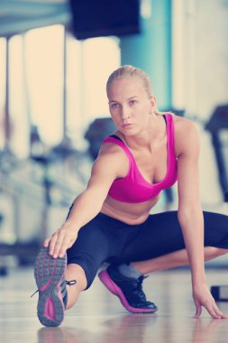 Sevimli genç kadın eğitiminin bir spor salonunda için Isınma ve germe
