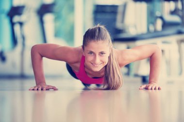 Isınma ve bazı yapıyor çok güzel sarışın kadın push up bir jimnastik salonu