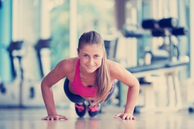 Isınma ve bazı yapıyor çok güzel sarışın kadın push up bir jimnastik salonu