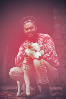 yakışıklı genç hipster adam ile birlikte beyaz husky köpek eski vintage retro Ahşap evin önünde ayakta