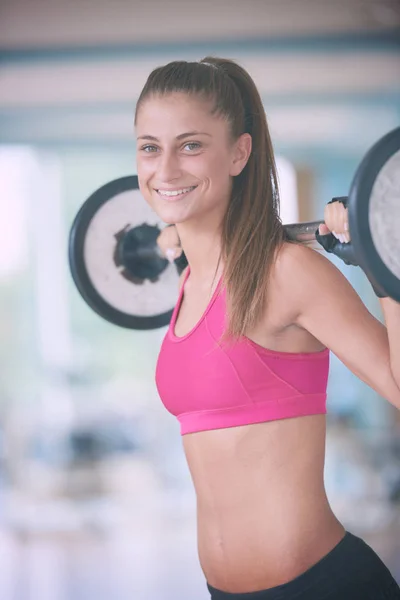 健康和适合年轻女子在健身房举重和工作在她的肌之肌肉 — 图库照片