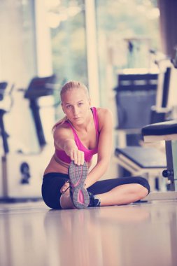 Sevimli genç kadın eğitiminin bir spor salonunda için Isınma ve germe