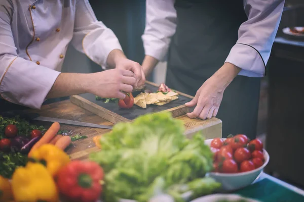 Team cooks and chefs preparing meal — Stock Photo, Image