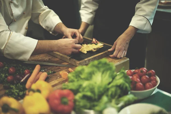 Team cooks and chefs preparing meal — Stock Photo, Image