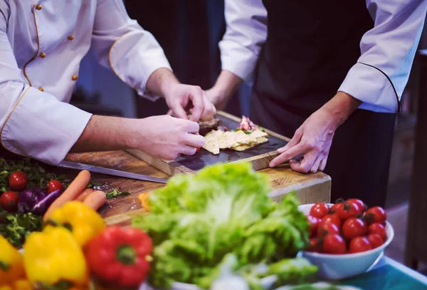 Cozinheiros de equipe e chefs preparando a refeição — Fotografia de Stock