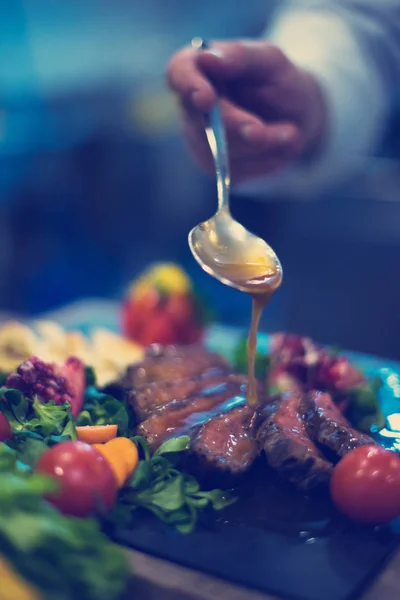 Chef tangan menyelesaikan steak piring — Stok Foto