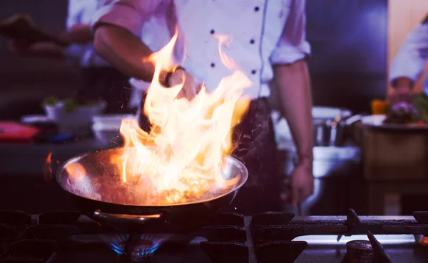 Kuchař dělá flambe na potraviny — Stock fotografie