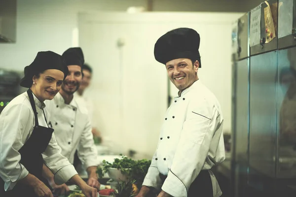 忙しいホテルやレストランのキッチンで食事を準備する専門チームの料理人やシェフ — ストック写真