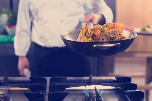 Šéfkuchař obracející zeleninu ve wok — Stock fotografie