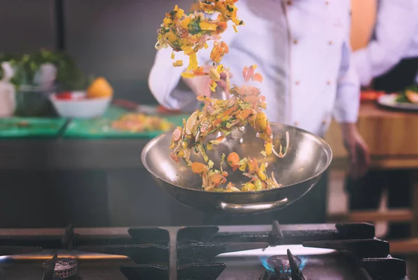 Šéfkuchař obracející zeleninu ve wok — Stock fotografie