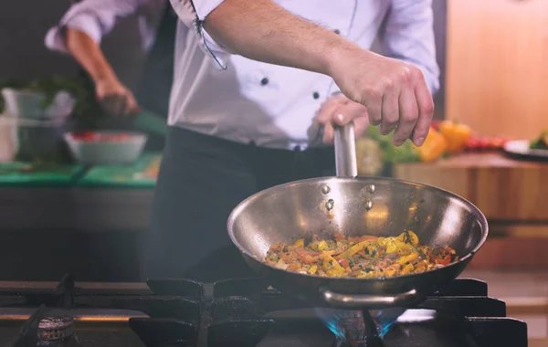 Chef colocando especiarias em vegetais em wok — Fotografia de Stock