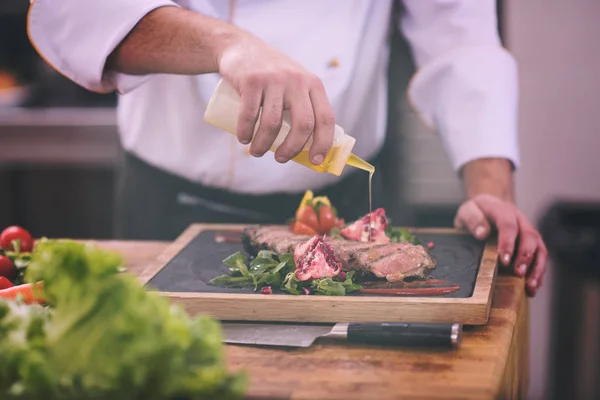 Chef-kok afwerking biefstuk vlees plaat — Stockfoto