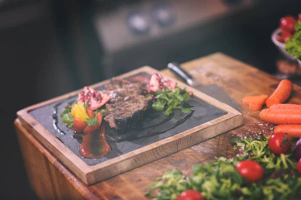 Juicy slices of grilled steak on wooden board — Stock Photo, Image