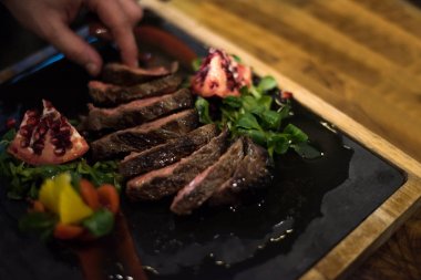 sığır eti biftek bitkisel bezemeli hizmet veren otel ya da Restoran mutfakta Şef closeup eller
