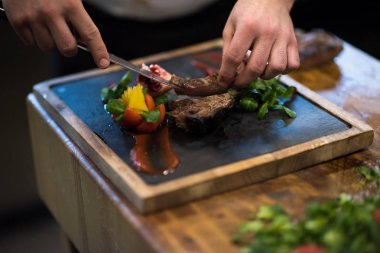sığır eti biftek bitkisel bezemeli hizmet veren otel ya da Restoran mutfakta Şef closeup eller