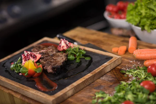 Juicy slices of grilled steak on wooden board — Stock Photo, Image